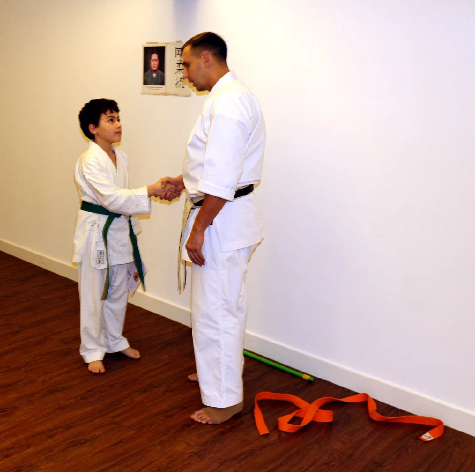 Sensei Aleksey Konovalov gratuliert Leon Rubinov zur bestandenen Grüngurt-Prüfung