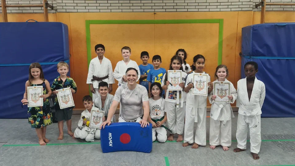 Kinder und Trainer nach den Karate-Gürtelprüfungen im Juli 2026