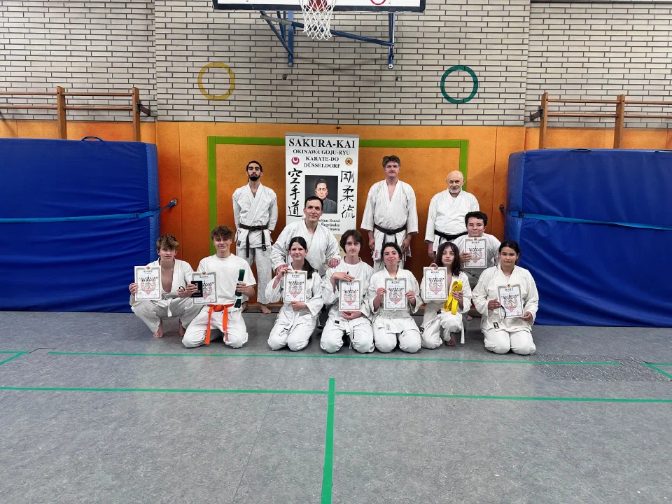 Erwachsene und Jugendliche nach den Karate-Gürtelprüfungen im Juni 2024