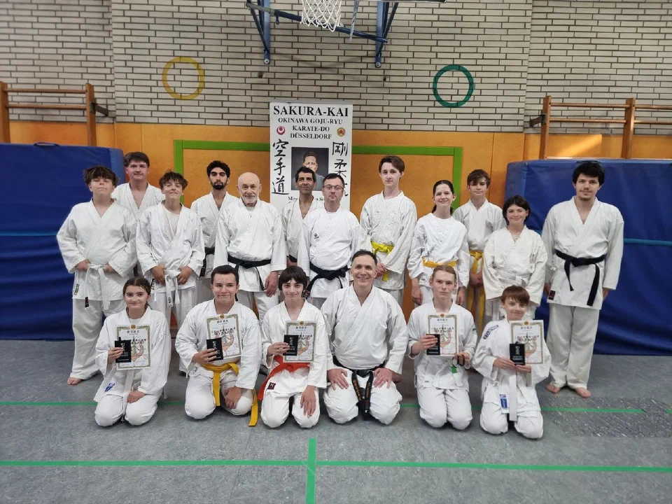 Jugendliche und Erwachsene nach der Sakura-Kai Karate-Prüfung im Sommer 2025